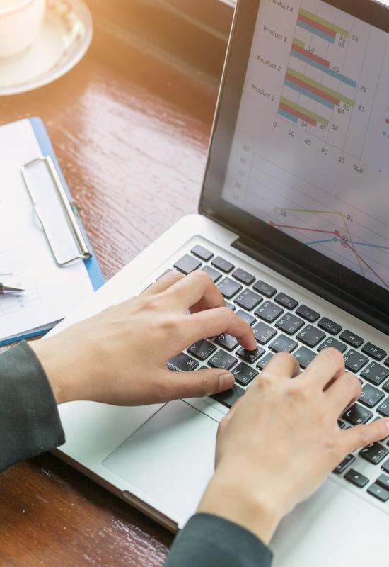 Geschäftsfrau arbeitet am Laptop mit Finanzdaten