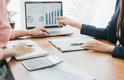 Geschäftsleute, die über die Diagramme und Schaubilder diskutieren, die die Ergebnisse ihrer erfolgreichen Teamarbeit zeigen.